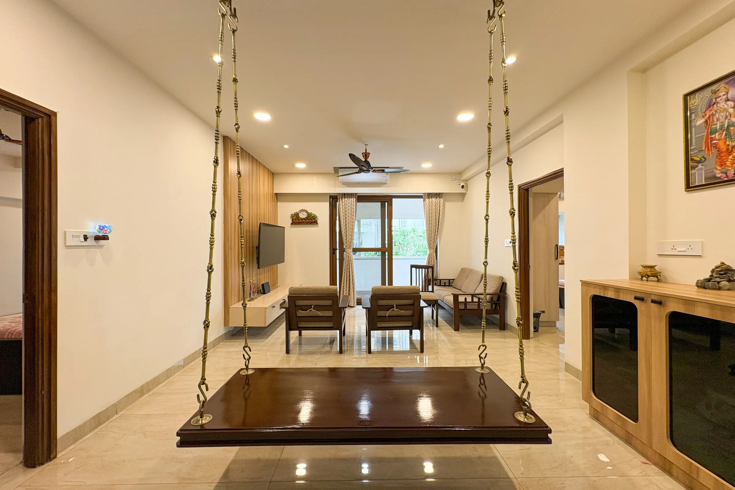 Living room with a wooden swing in the Alwarpet 3BHK home by Crafted Haven